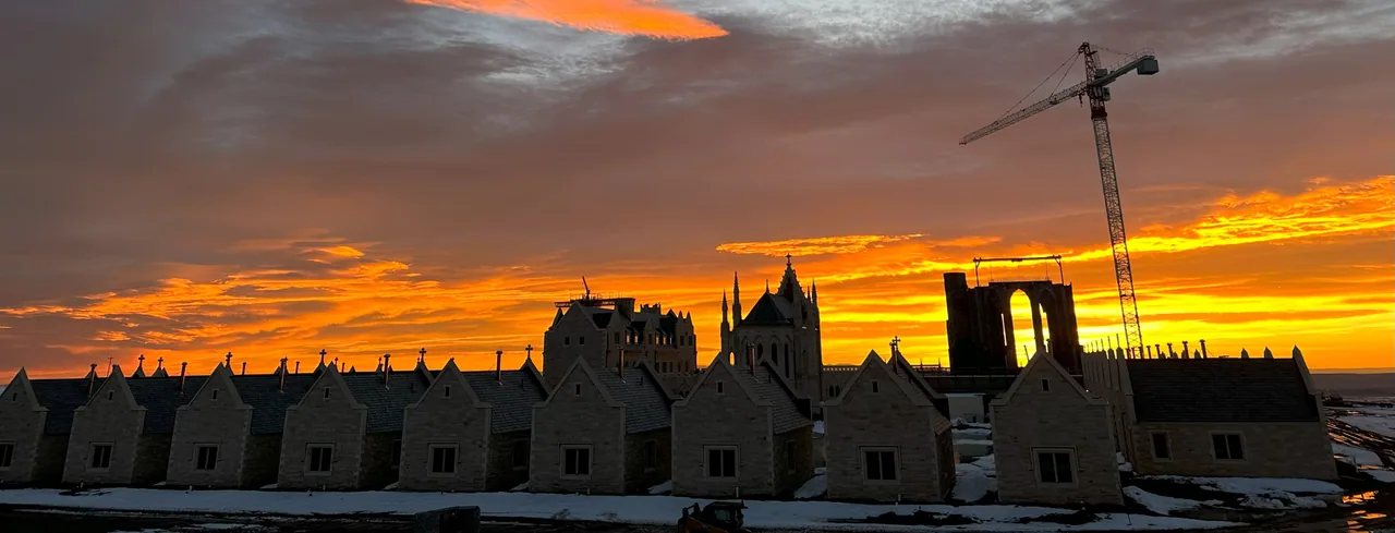 The monastery at sunrise, its chapel spire and Chapter House silhouetted against the sky