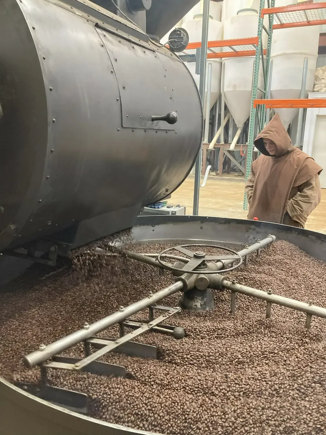 A monk tending the coffee roaster in the monastery workshop