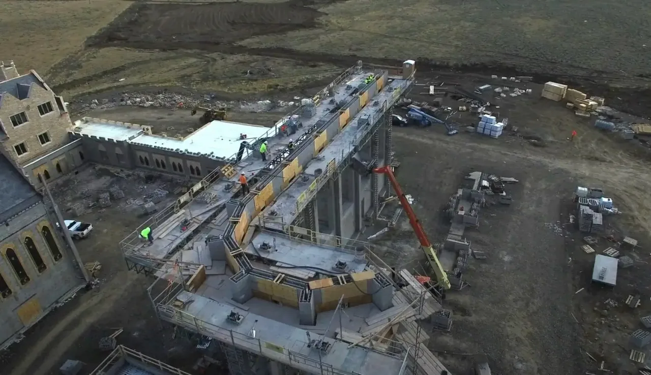 Aerial view of the Chapel walls rising, with a crane overhead