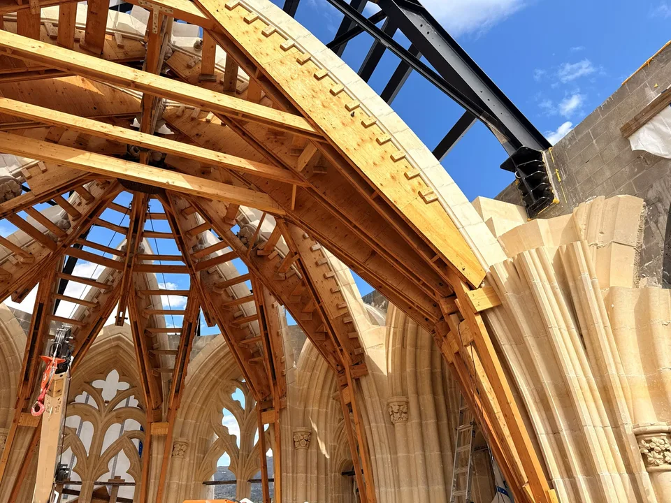 Wooden formwork supports stone arches during construction