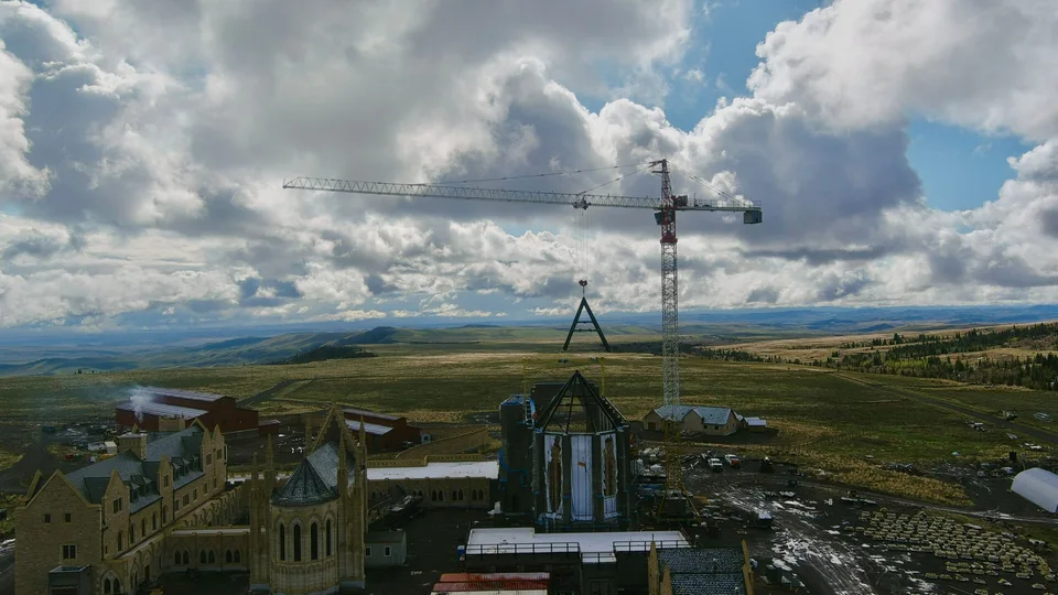 A tower crane sets the Chapel’s roof trusses at the monastery