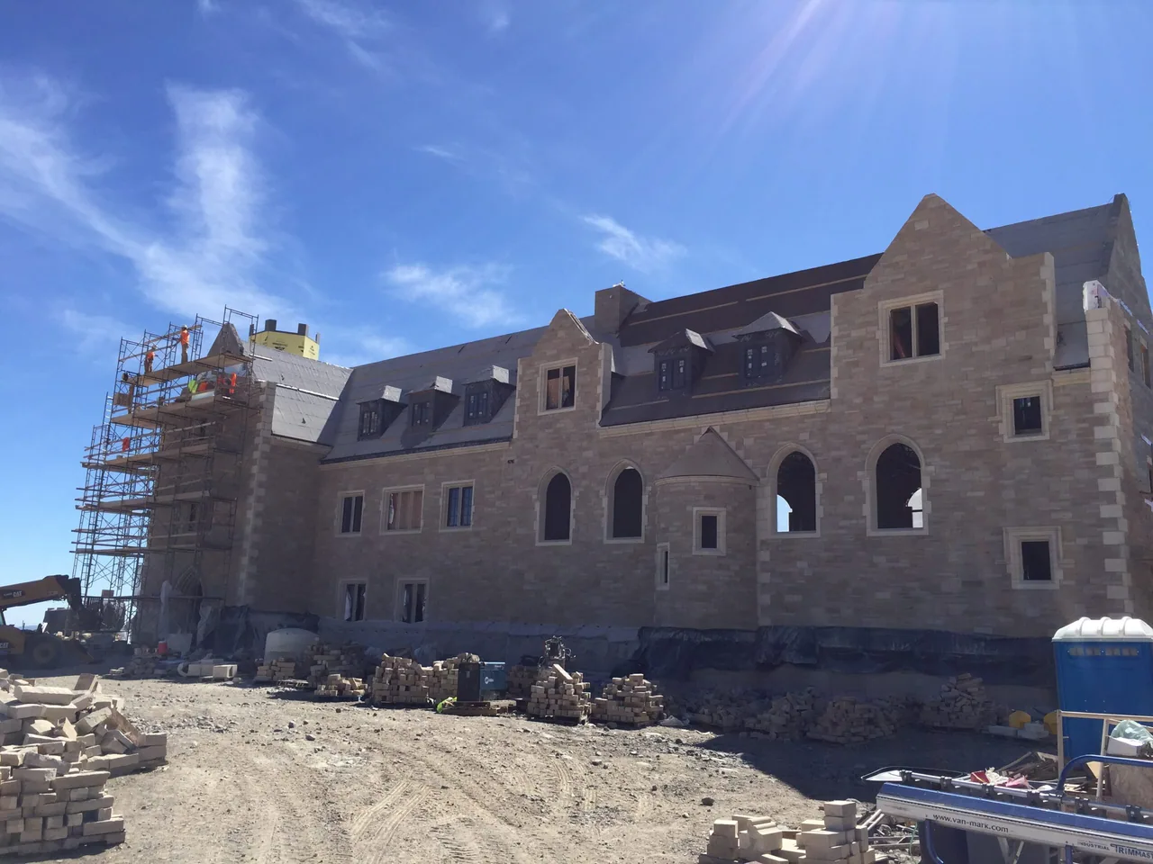 The Refectory building under construction, with scaffolding and cut stone